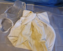 Wet terry nappy from last night's bed wetting on rubber  cot  sheet